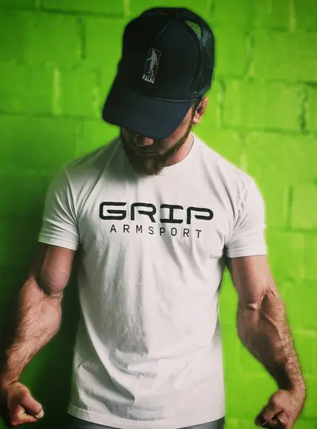 A man wearing a cap and shirt with the word " grip armoury ".